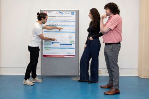 Eine Gruppe Wissenschaftler:innen schaut auf ein Poster